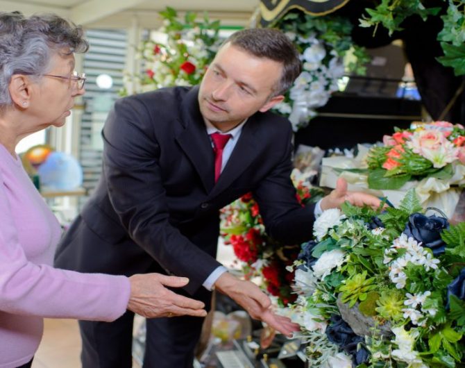 elderly woman buying flowers at funeral service