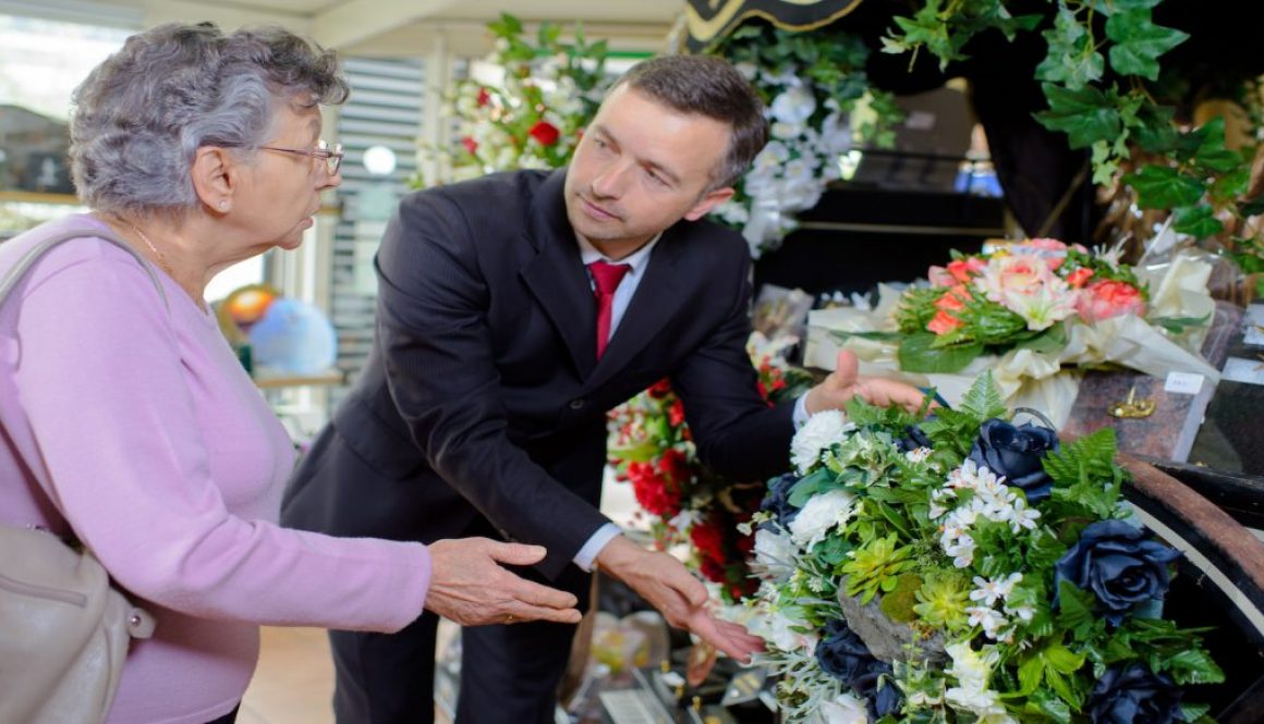 elderly woman buying flowers at funeral service