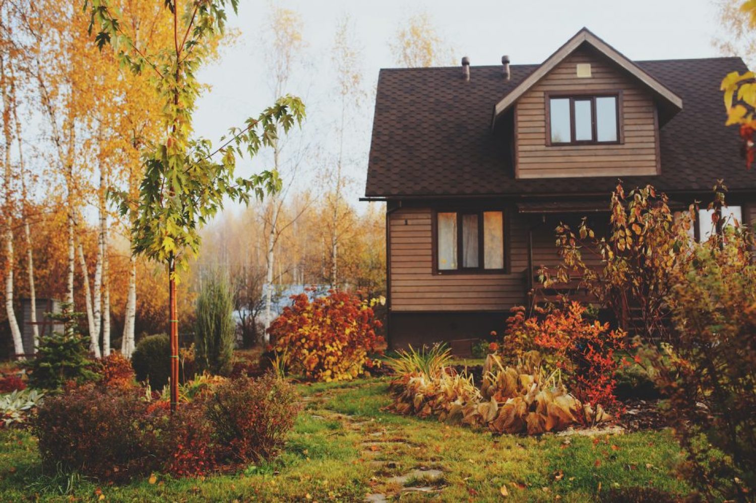 autumn wooden country house and garden view