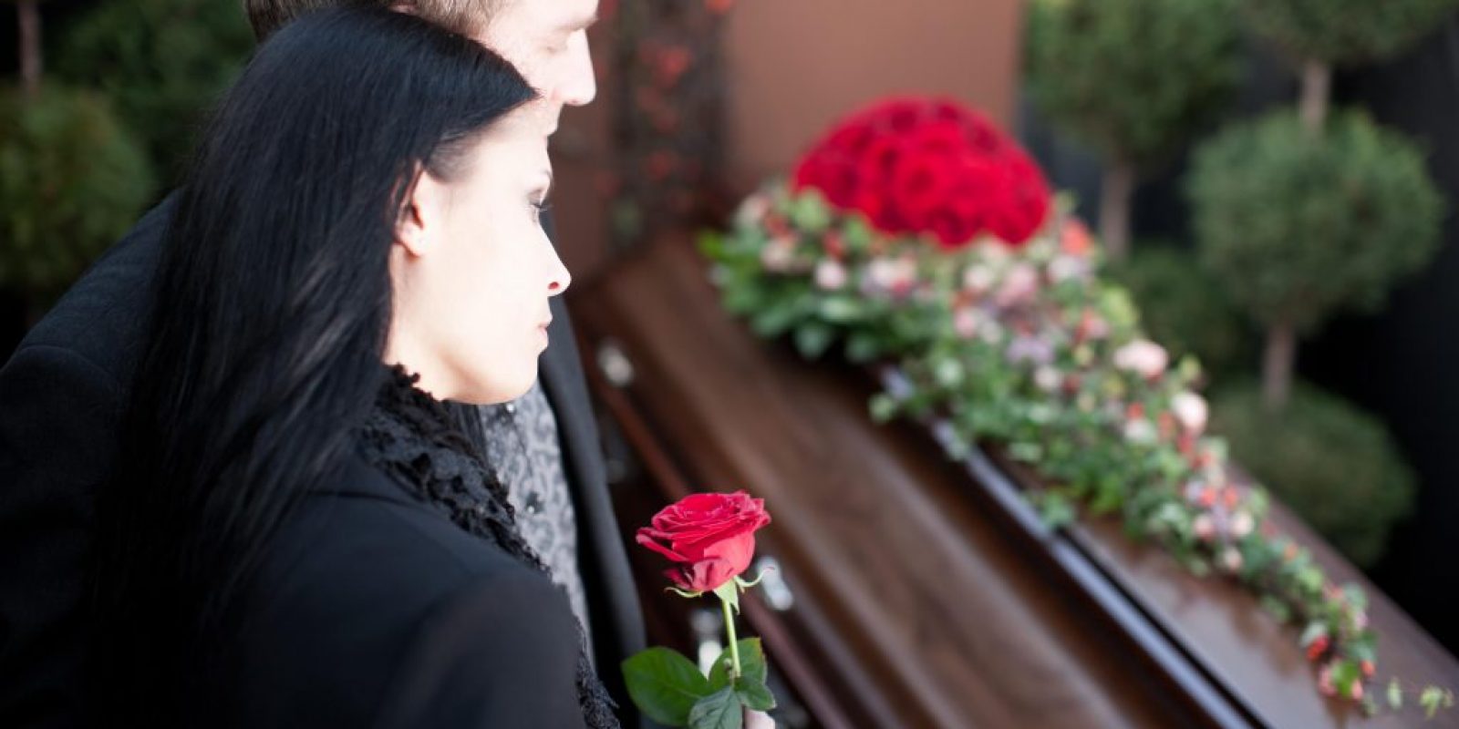 Paar bei Beerdigung mit Sarg